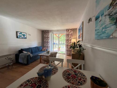 a living room with a blue couch and a table at Łagów apartament z plażą i pomostem in Łagów