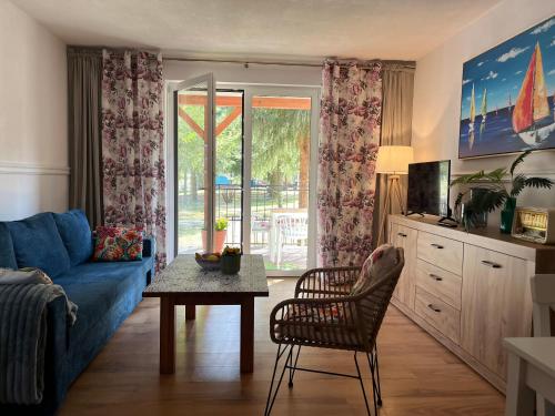 a living room with a blue couch and a table at Łagów apartament z plażą i pomostem in Łagów