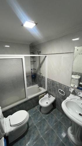 a bathroom with a toilet and a sink and a tub at Nador in Nador