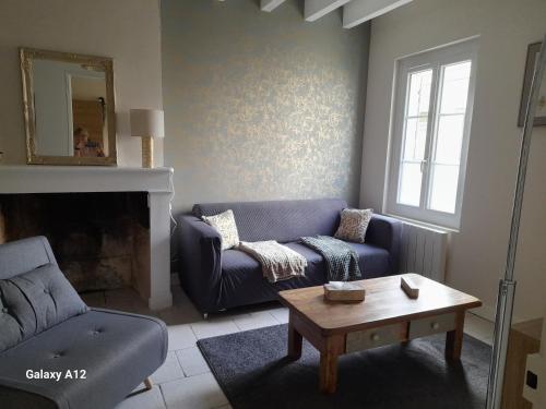 a living room with a blue couch and a coffee table at Maison centre ville Bourgueil in Bourgueil