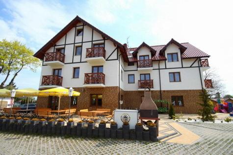 a large white building with a patio in front of it at Klif Spa in Jarosławiec
