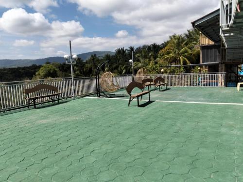two benches sitting on a tennis court at MGS viewdeck resort in Samal