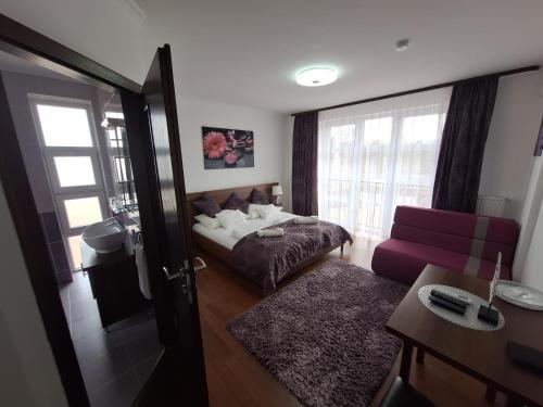 a room with a bed and a couch and a window at Villa Rózsa Vendégház in Erdőbénye