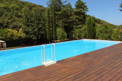 een zwembad op een houten terras bij Casa Fogli Casa Vacance & Events in Campiglia Marittima