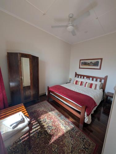 a bedroom with a bed and a chair and a rug at The Gympie Empire in Gympie