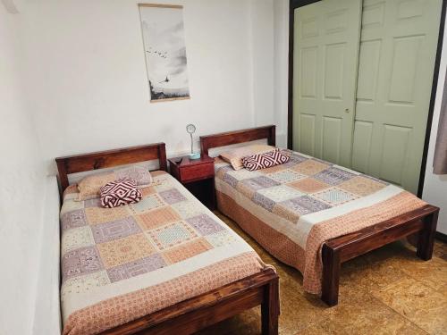 two beds sitting next to each other in a room at Apartamento 8 TEC in Cartago