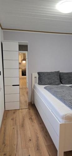 a bedroom with a white bed and a wooden floor at Ferienwohnung Nikolaus in Bernkastel-Kues