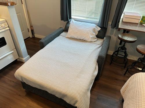 a bed in a small room with a table at The Hut at Deer Hollow in Three Rivers