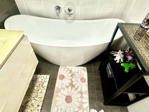 a white bath tub in a bathroom with a sink at Backpacker Bunks and Queen Pool Clifton Beach in Clifton Beach