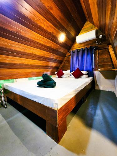 a large bed in a room with wooden walls at Pearl Bolgoda in Piliyandala