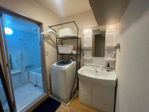 a small bathroom with a sink and a shower at Yoshimi Stay Kawaguchi in Kawaguchi