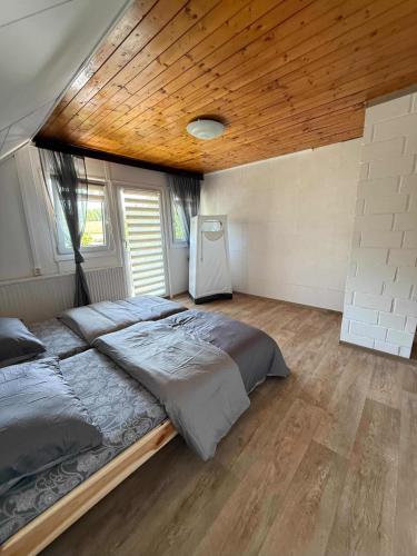 a bedroom with a large bed with a wooden ceiling at Jarmila in Tachov