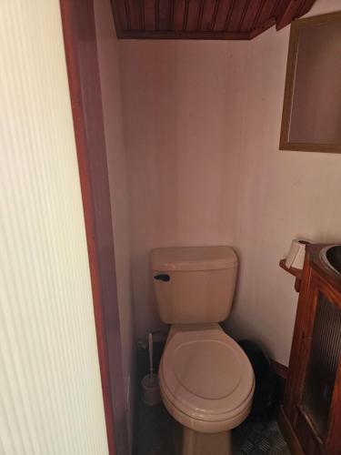 a bathroom with a toilet in a small room at Cabaña cerca del TEC in Cartago