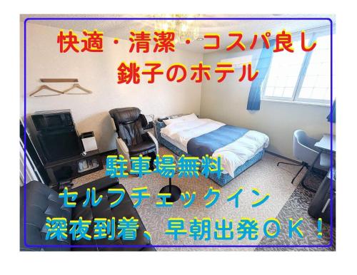 a room with a bed and a desk and a television at セルフプラスホテル銚子無人ホテル in Choshi