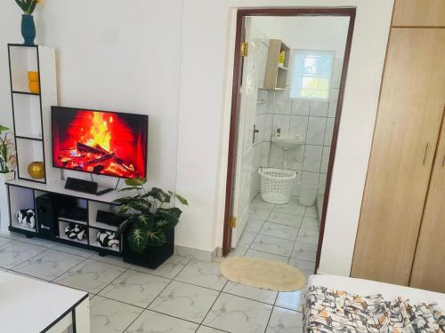 a living room with a flat screen tv on a wall at Tash Studios in Diani Beach
