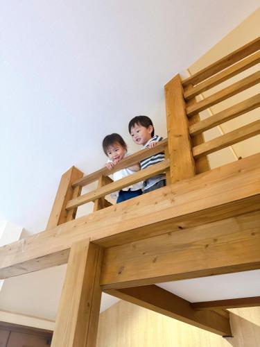 two children standing in a loft bed at 1日1組限定 一棟貸し Japanese Traditional House Three Field Tamba-Sasayama in Sasayama