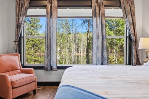 a bedroom with a bed and a chair and windows at Blanchard Bliss in Blanchard