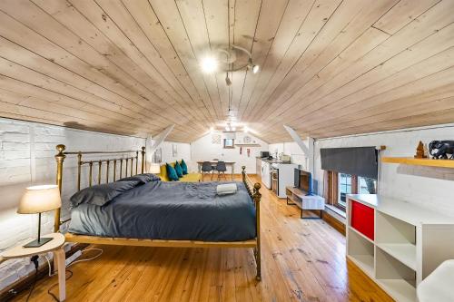 a bedroom with a bed and a wooden ceiling at Lee Valley Lodge Upper Floor in Cheshunt