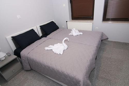 a bed with swans on it in a bedroom at Hotel Korzo in Bitola