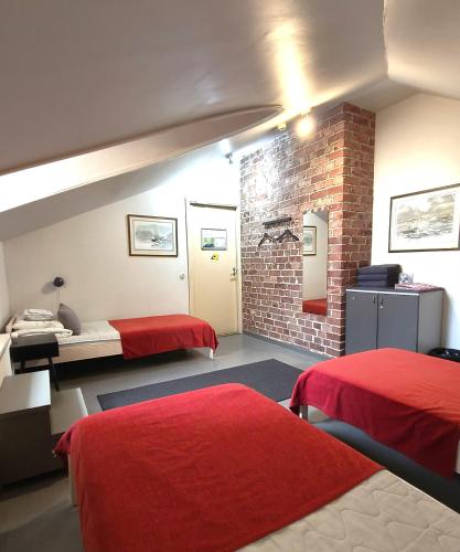 ein Zimmer mit zwei Betten und einer Ziegelwand in der Unterkunft Hostel Suomenlinna in Helsinki