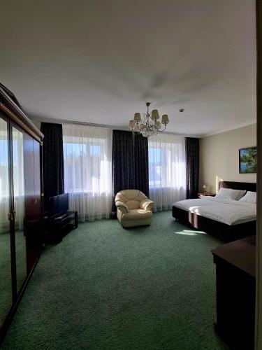 a hotel room with a bed and a chair at Nurtau in Pavlodar