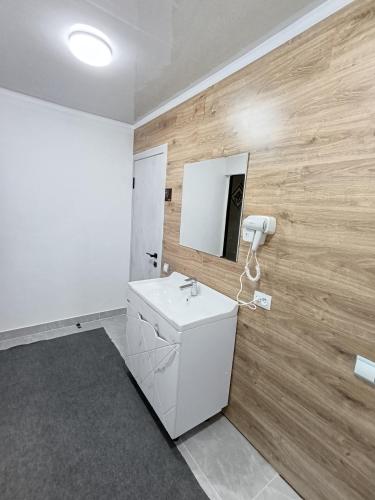 a bathroom with a white sink and a mirror at KAPCHYGAI Guest house in Teploklyuchinskoye