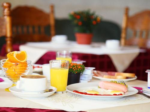 a table topped with plates of breakfast foods and orange juice at Amsterdam Hotel in Saint Petersburg