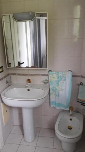 W łazience znajduje się umywalka, toaleta i lustro. w obiekcie B&B Sun Garden w mieście Montoro Inferiore