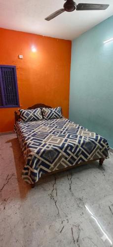a bed in a room with an orange wall at Girivalam Nest in Jāmb