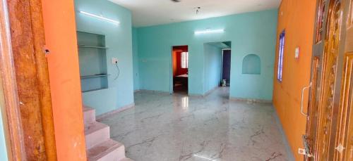 an empty hallway with stairs and blue walls at Girivalam Nest in Jāmb