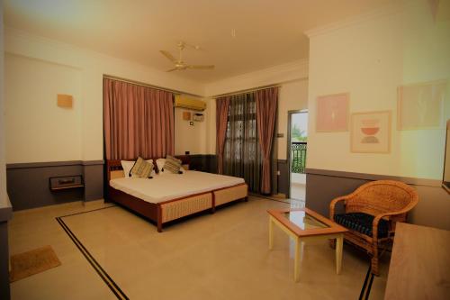 a bedroom with a bed and a chair and a table at Hotel Gargo Tower in Guwahati
