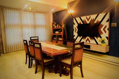 a dining room with a table and chairs and a television at Hotel Gargo Tower in Guwahati