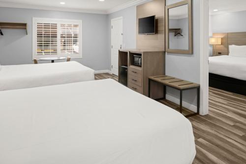 a hotel room with two beds and a mirror at Lone Oak Lodge in Monterey