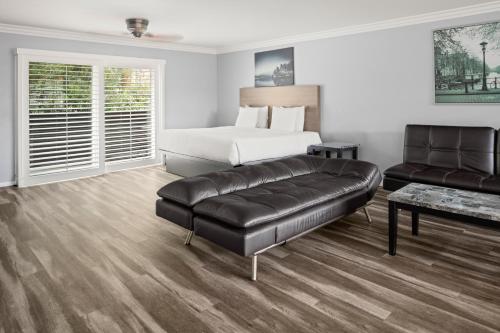 a bedroom with a bed and a leather couch at Lone Oak Lodge in Monterey