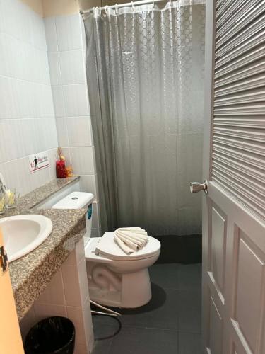 a bathroom with a toilet and a shower and a sink at Flowernight Guesthouse in Kata Beach