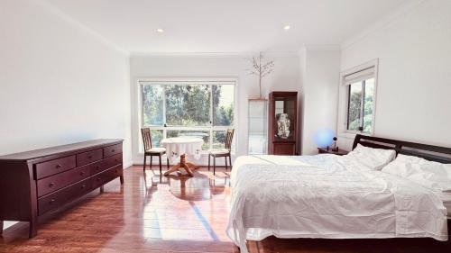 a bedroom with a bed and a table and chairs at Golf Course Frontage House in Schofields
