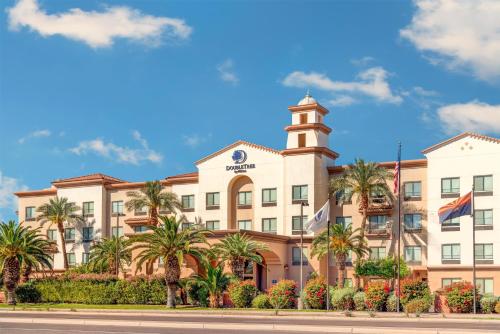 a large building with palm trees in front of it at DoubleTree by Hilton Phoenix-Gilbert in Gilbert