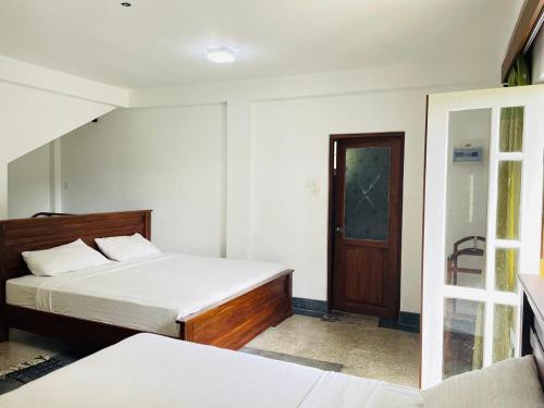a bedroom with a bed and a door to a room at Summit resort in Balangoda
