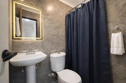 a bathroom with a toilet and a sink and a shower at Downtown, Comfortable Loft, in Hermosillo
