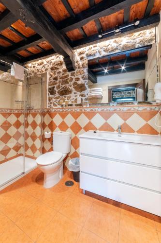 a bathroom with a toilet and a tub and a sink at La Quintana de Los Valles in Benia de Onís