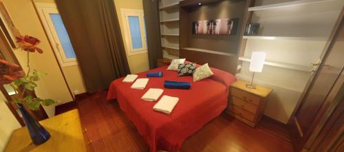 Un dormitorio con una cama roja con toallas. en Zen Apartment Gran Canaria, en Las Palmas de Gran Canaria