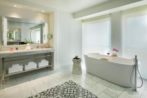 a bathroom with a tub and a large mirror at The Fontaine in Kansas City