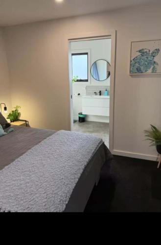 a bedroom with a bed and a bathroom with a mirror at Swansea Cabins in Swansea
