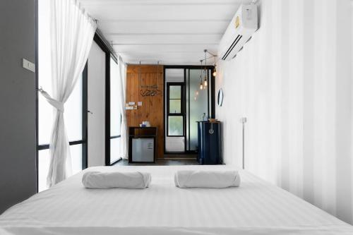 a white bed in a room with a large window at serene hotel in Chiang Mai