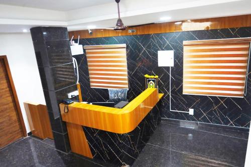a yellow tub in a bathroom with black tiles at Mantra Lodge in Shimoga
