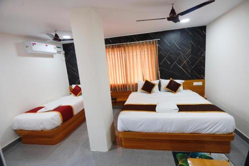 a bedroom with two beds in a room at Mantra Lodge in Shimoga