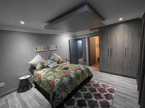 a bedroom with a bed and a cabinet and a rug at XLA Home Guest house in eMalahleni