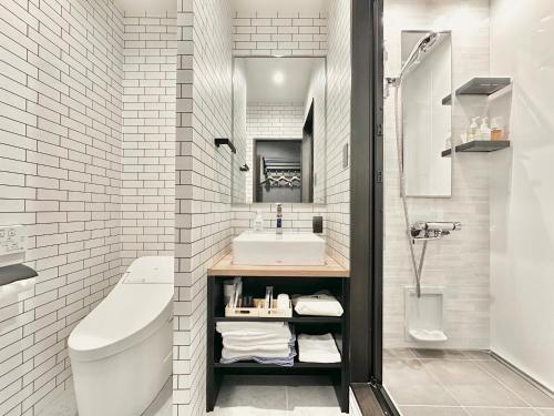 ein weißes Badezimmer mit Waschbecken und Toilette in der Unterkunft Hotel Sun Road in Amakusa