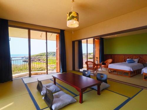 a bedroom with a bed and a table and chairs at Garden BBQ and Stay ANCHOR in Miyakojima