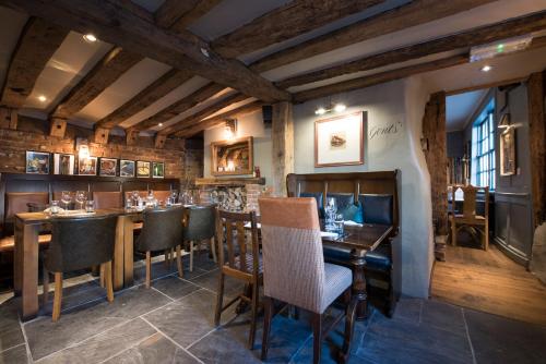 a restaurant with a bar with tables and chairs at The Ostrich Inn Colnbrook London Heathrow in Slough